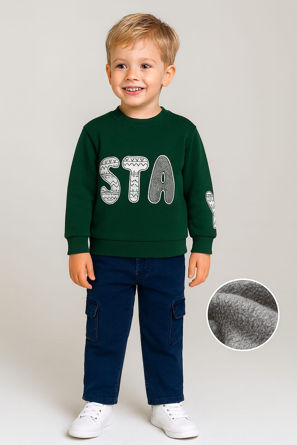 Child wearing a green sweatshirt with 'STA' and navy pants on a light gray background